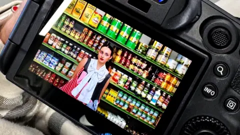 Southampton Forward A girl with a bold outfit stood in front of shelves inside a corner shop.