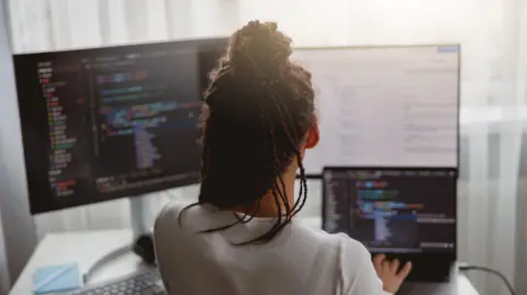 Getty Images Stock image of a woman looking at code on a screen