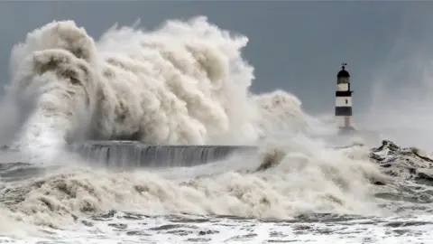 PA Waves crash into the sea wall at Seaham Harbour