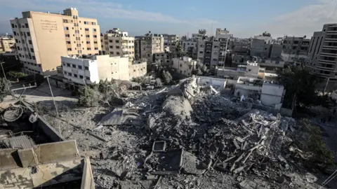 EPA Palestinians inspect remains of Hamas interior ministry building in Gaza City destroyed in Israeli air strike (13 November 2018)