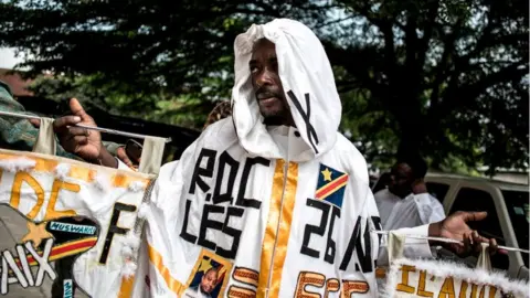 Getty Images A supporter of DRCongo Official Presidential candidate, Emmanuel Ramazani Shadary poses in Kinshasa on November 24, 2018