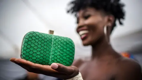 FAO/Luis Tato Model holds a green fish skin clutch