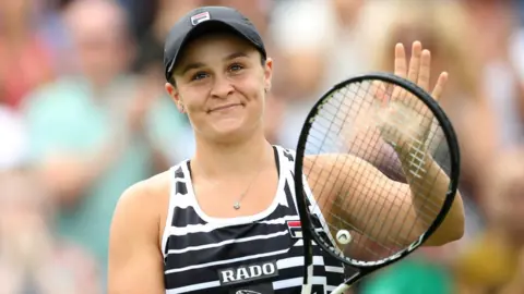Reuters Ashleigh Barty smiles on court and claps with her racquet at Birmingham