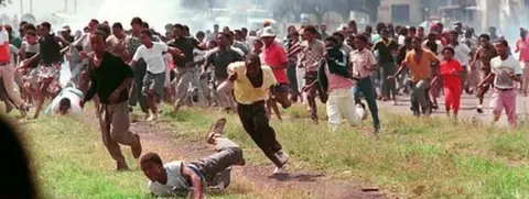 Getty Images People fleeing from tear gas in Sharpeville, South Africa, in March 1990