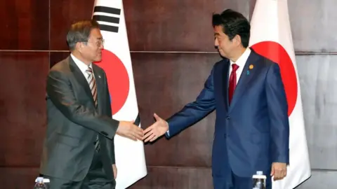 Reuters South Korean President Moon Jae-in shakes hands with Japanese Prime Minister Shinzo Abe in Chengdu, China, 24 December 2019