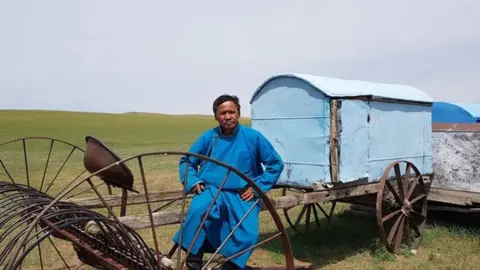Batmunkh Batmunkh sitting on farming equipment