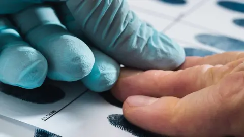 Getty Images/D-Keine Suspect having fingerprints taken