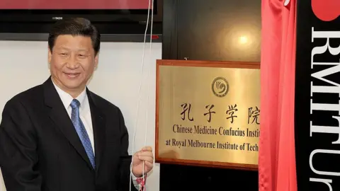 Getty Images President Xi unveiling a plaque for the Chinese Medicine Confucius Institute at the Royal Melbourne Institute of Technology