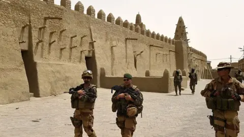 Getty Images French soldiers of the 93rd Mountain Artillery Regiment and soldiers of the Malian Armed Forces patrol next to the Djingareyber Mosque on June 6, 2015 in Timbuktu