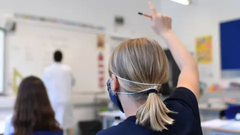 Getty Images A pupil raises her hand at a school in England
