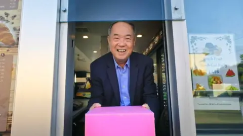 Greenwich Entertainment  Ted with the iconic pink doughnut box he popularised