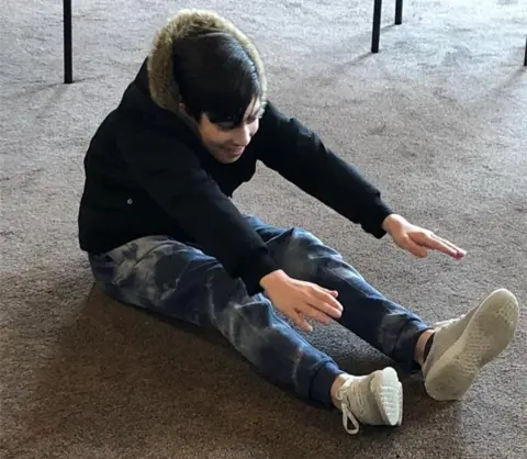 Shamsa Aslam Mehdi stretching for his toes at the Sunday education support group