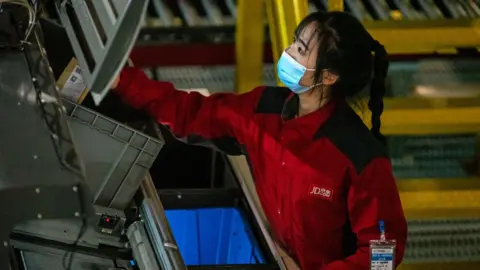 Getty Images A woman works at the Jingdong logistics centre in southern Beijing, one of the largest in Asia.