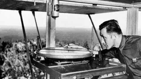 Getty Images A lookout using an Osborne Fire Finder at a tower overlooking Coconino Nation Forest in 1941
