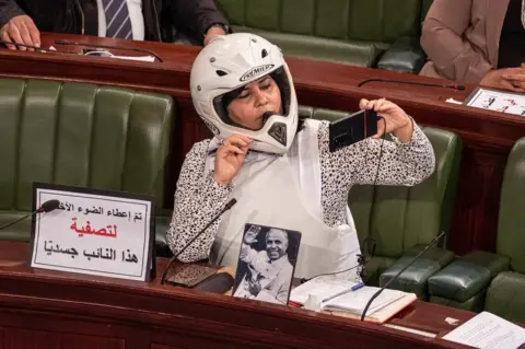 Shutterstock Abir Moussi wearing a helmet and a flak jacket in parliament