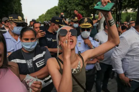 Getty Images A woman is seen shouting at the front of a group of protesters in June 2021.