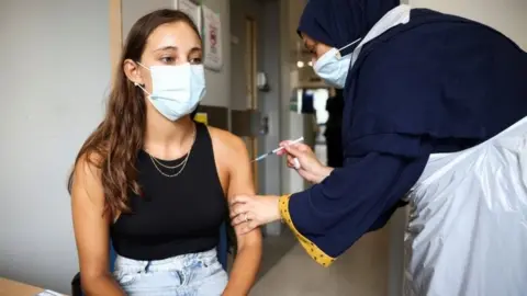 Reuters A woman getting the Pfizer jab