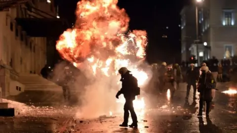 AFP A petrol bomb explodes next to riot police in Athens. Photo: 7 November 2012
