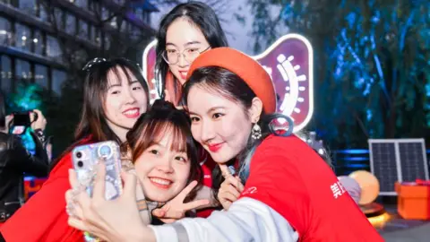 Getty Images Employees take selfies at Alibaba Group's Hangzhou headquarters ahead of the China's Double 11 Shopping Festival on November 10, 2021 in Hangzhou, Zhejiang Province of China.