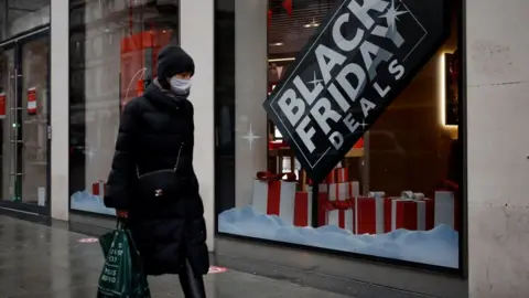 Getty Images Shopper walks past Black Friday deal sign