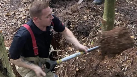 West Midlands Fire Service  Firefighter digging in Sutton Park