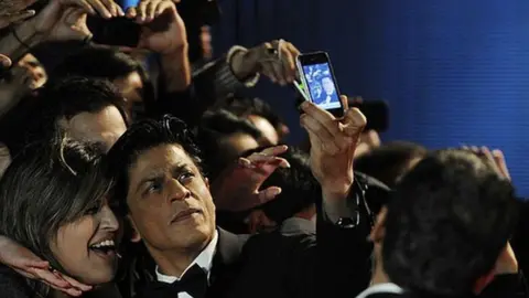 Getty Images Actor Shah Rukh Khan poses with fans as he attends the UK premiere of Ra One at the O2 Arena on October 25, 2011.