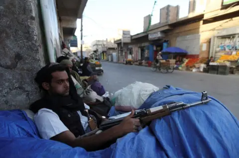 Reuters File photo of a Houthi fighter sitting behind sandbags near a checkpoint in Sanaa