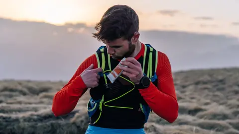 Getty Images Runner tucks away a protein bar snack