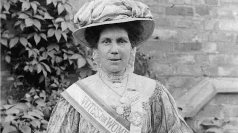 Hawkins family Alice Hawkins with a Votes for Women sash and poster