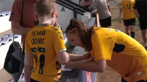 John Fairhall/BBC Francesca Partridge, footballer signing autograph