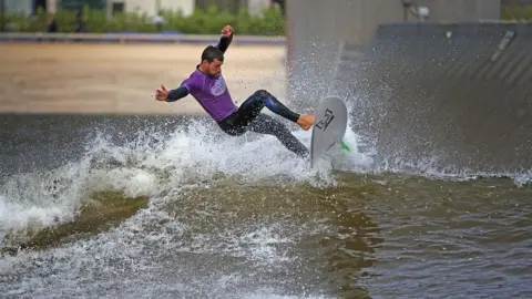 Getty Images DOLGARROG, WALES - AUGUST 05: Senior Instructor Rick Velk rides a wave at Surf Snowdonia on August 5, 2016 in Dolgarrog, Wales. Surf Snowdonia is the world's first inland surf lagoon featuring pioneering technology which has made an Olympic dream a reality for British surfers. The International Olympic Committee (IOC) has announced its decision to include surfing in the Tokyo 2020 Olympics. The lagoon creates a perfect wave for surfers and was central to the inclusion of surfing in the Olympic Games. Surf Snowdonia will be crucial training facility for first ever surfing Team GB. (Photo by Christopher Furlong/Getty Images)