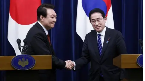 EPA South Korean President Yoon Suk Yeol (L) and Japanese Prime Minister Fumio Kishida (R) shake hands following a joint news conference at the prime minister"s official residence in Tokyo, Japan, 16 March 2023.