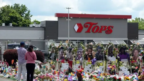Getty Images Community members pay respects outside the Tops Friendly Market in Buffalo, New York