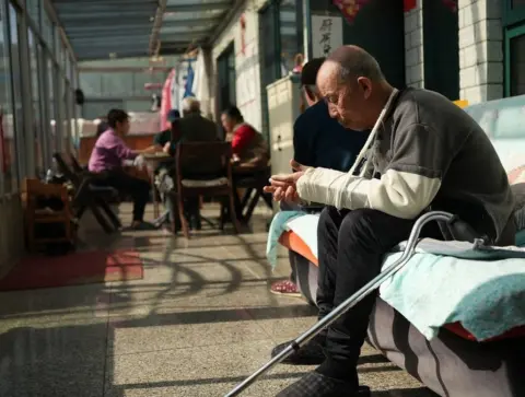 Xiqing Wang/ BBC  Residents in the conservatory at the care home run by Guohui Tang