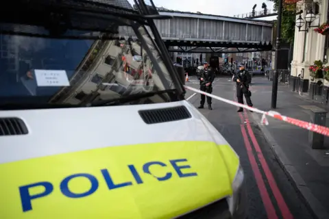Getty Images Police van stands next to tape marking the area of Borough Market where Saturday's attacks took place; police officers stand watch behind