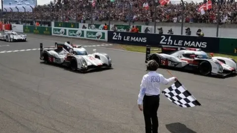 Getty Images Audi team crosses the finish line to take the chequered flag in its 379th and last lap to win the 82nd Le Mans 24 Hour Race