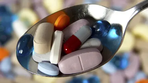 Getty Images A spoon with a range of pills on it