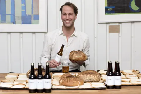 TOM MOGGACH Toast founder Tristram Stuart sitting surrounded by bread and Toast beer