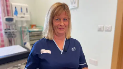 BBC Head and shoulders image of Maureen Wood, a senior charge nurse at Ninewells Hospital's Assisted Conception Unit, looking straight at the camera. She has shoulder-length blonde hair and is wearing a navy nurses tunic.