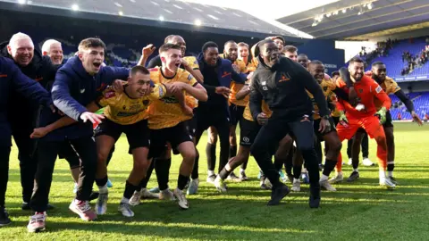 PA Media Maidstone United manager George Elokobi celebrates with the players after the Emirates FA Cup fourth round match at Portman Road, Ipswich. 