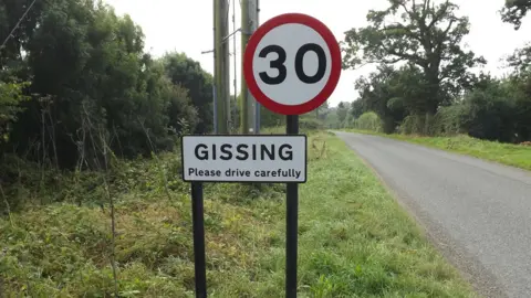 Geographer Village road sign for Gissing with 30mph 