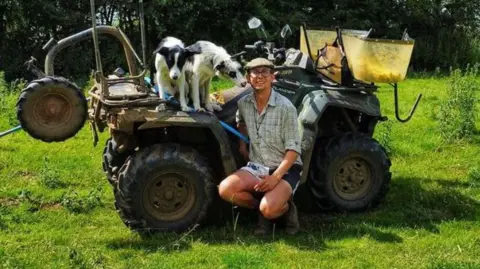 Karl Franklin Karl Franklin smiling for the camera with his dogs next to a tractor on a sunny day.