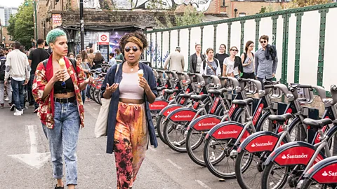 Nicola Ferrari/Alamy Women stroll in Shoreditch past the city’s shared bicycles, a scheme that launched in 2010 (Credit: Nicola Ferrari/Alamy)