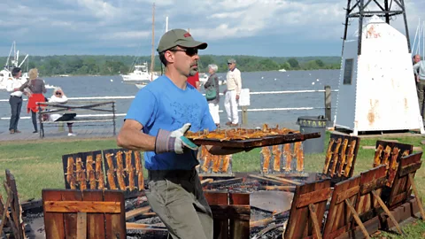 Ashley Winchester Workers carry shad from the fire to awaiting servers with assembly-line accuracy (Credit: Ashley Winchester)