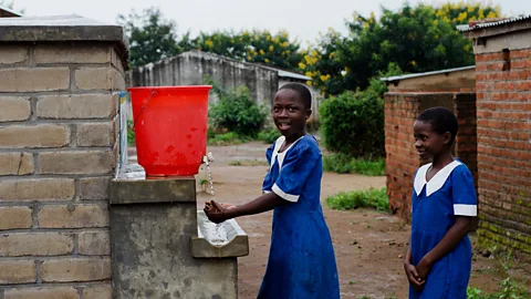 Getty Images Girls wash their hands at their school’s facilities in Malawi – one example of how people’s behaviour can be changed to save lives (Credit: Getty Images)