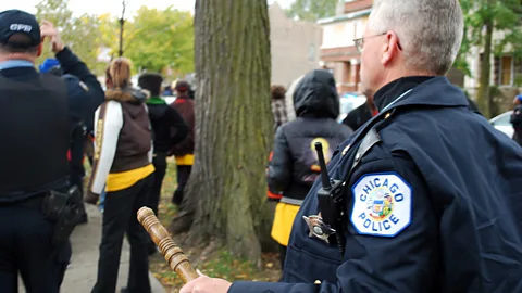 Getty Images A fight breaks out outside of a Chicago high school in 2009; Cure Violence’s approach involves calming people down before the conflict escalates to violence (Credit: Getty Images)