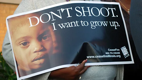 A woman holds a poster at an anti-violence rally on Chicago’s South Side