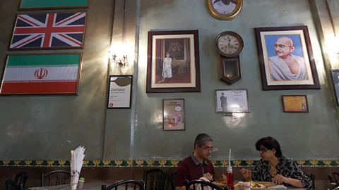 Indranil Mukherjee/Getty Images Britannia & Co Restaurant, with its Union Jack flag and image of Queen Elizabeth II, is one of Mumbai's most famous Irani cafes (Credit: Indranil Mukherjee/Getty Images)