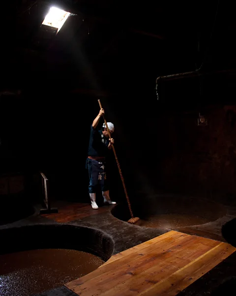 Ryouchin/Getty Images Very little soy sauce is still made in the traditional way, using wooden barrels and long paddles (Credit: Ryouchin/Getty Images)