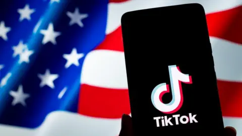 Getty Images A TikTok logo is displayed on a smartphone with the US flag in the background